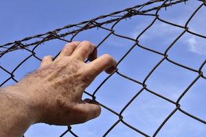 Hand on metal fence